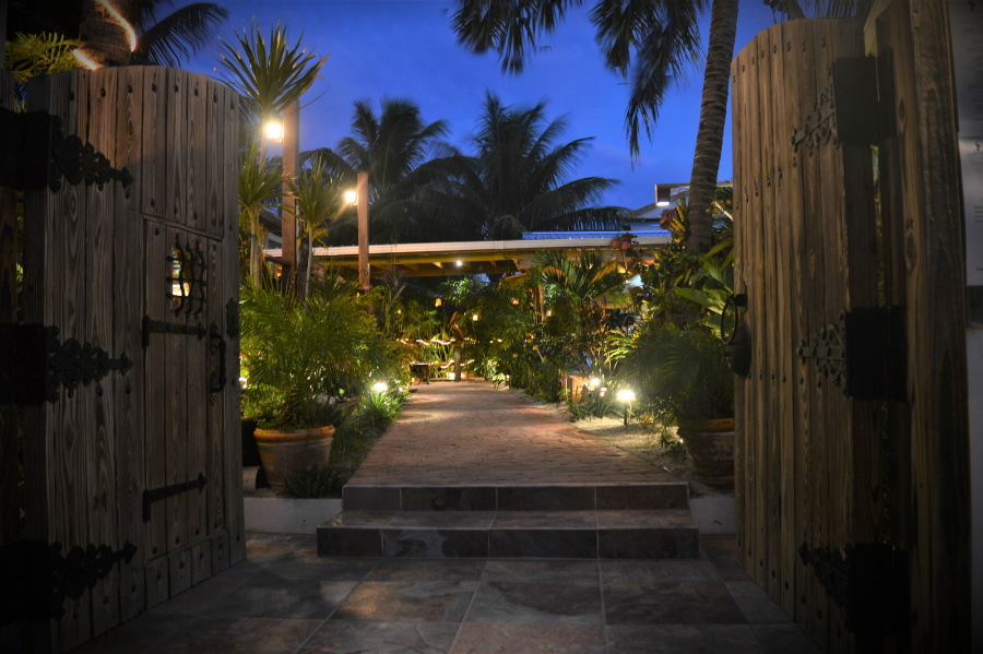Tropical garden walkway with heavy wooden doors in a classy restaurant on Caye Caulker